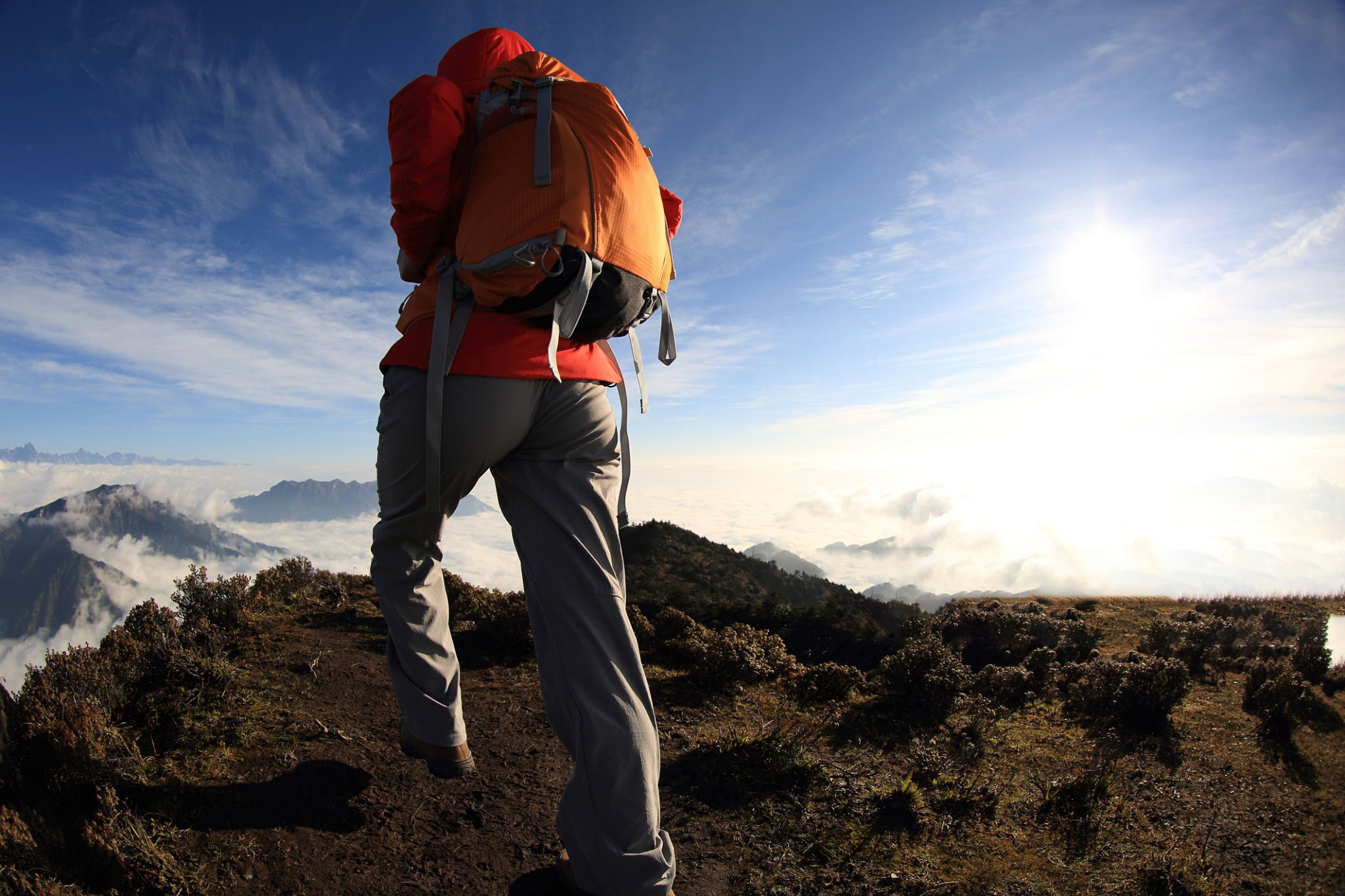 young woman hiker on beautiful rolling clouds mountain peak